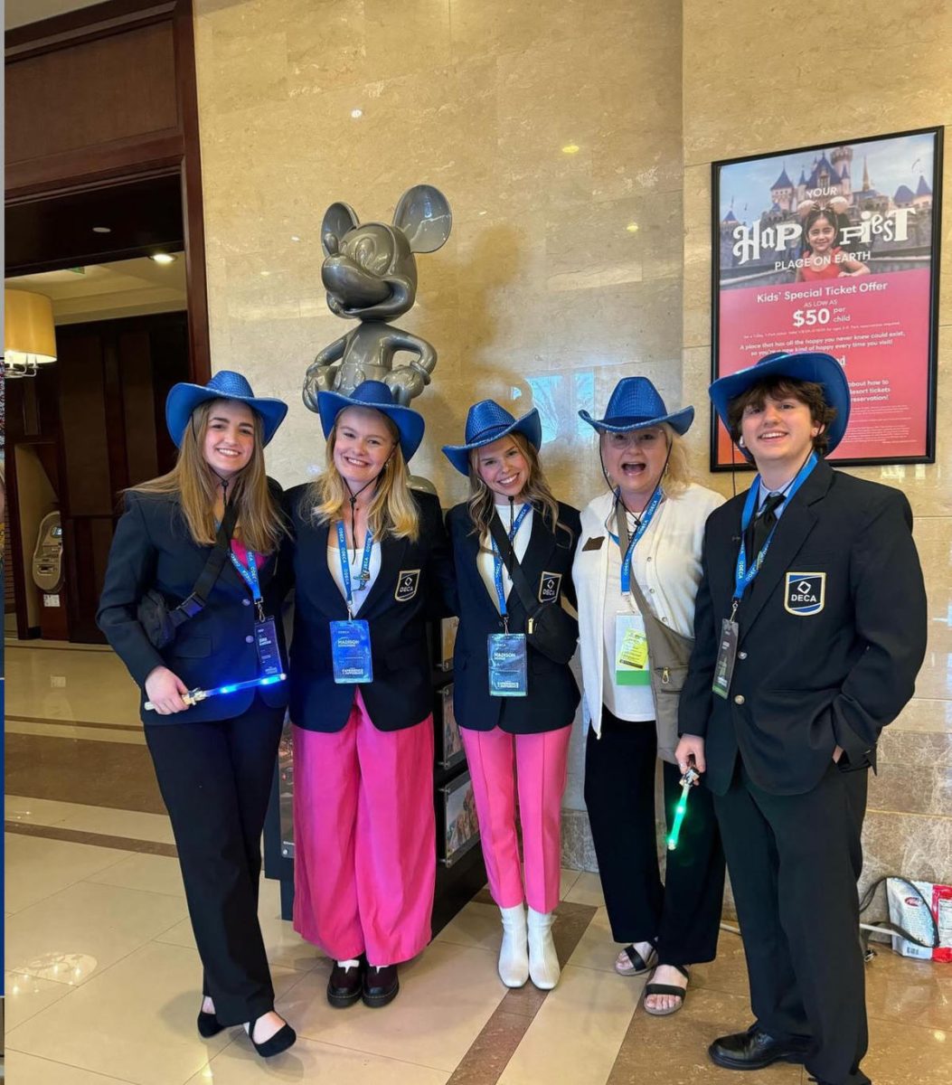 (From left to right) Jenna, Madison Sorenson, Madison Hodge, Mrs. Lamoureux, and Aiden Craft posing in front of a gray Mickey Mouse statue at the Anaheim Convention Center.