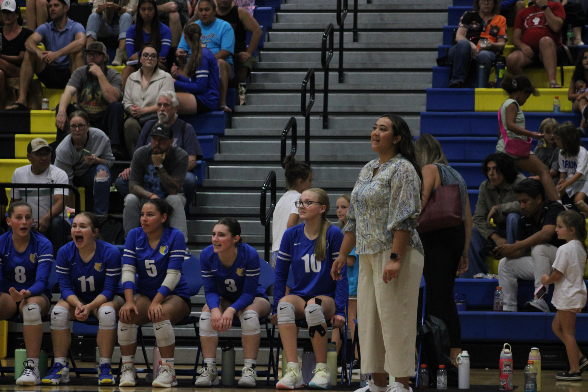 Coach Lihau Perreira observes the volleyball game from the bench.