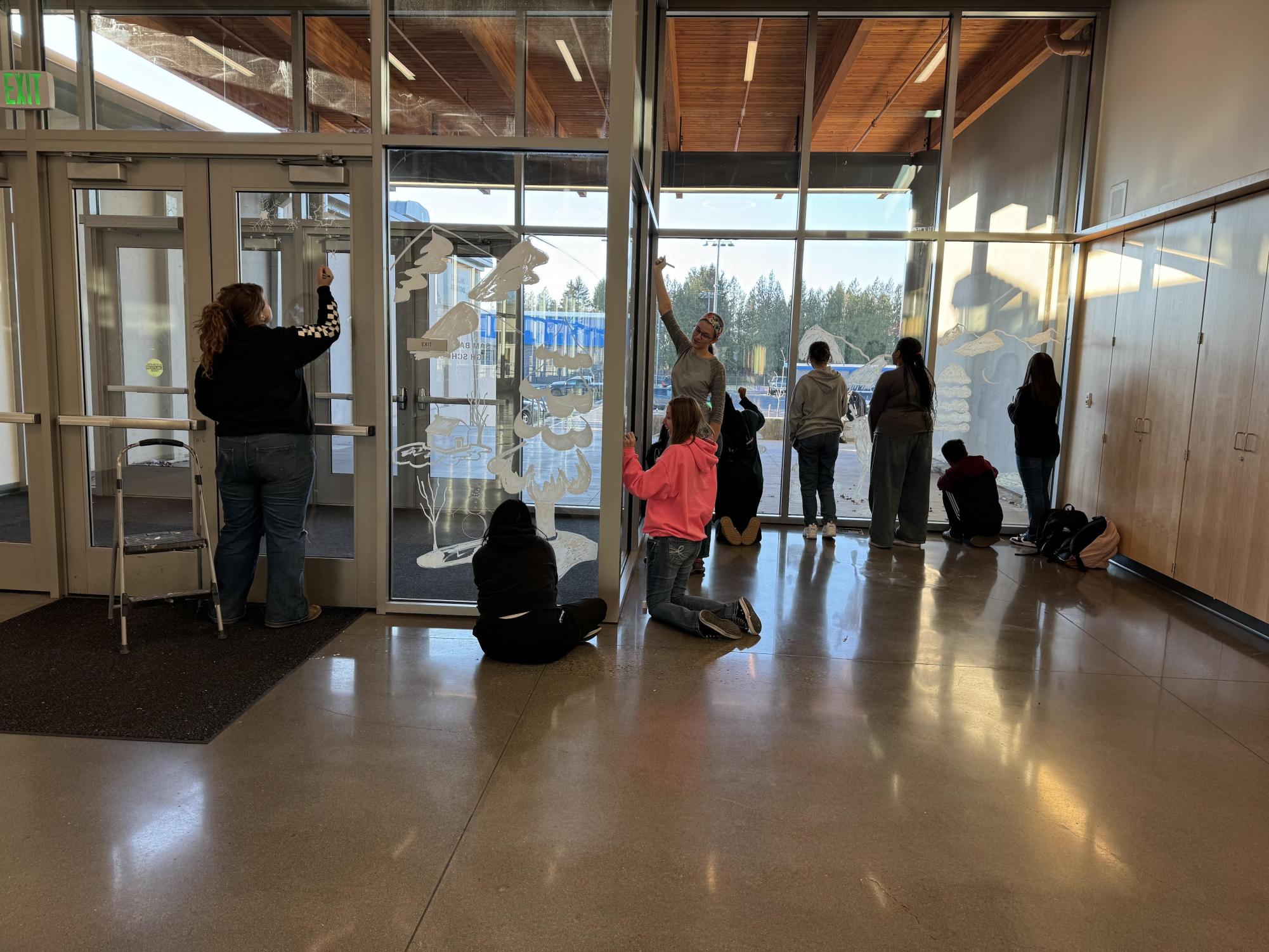  NAHS members decorating Sam Barlow’s windows and doors with a winter theme for their volunteer hours.