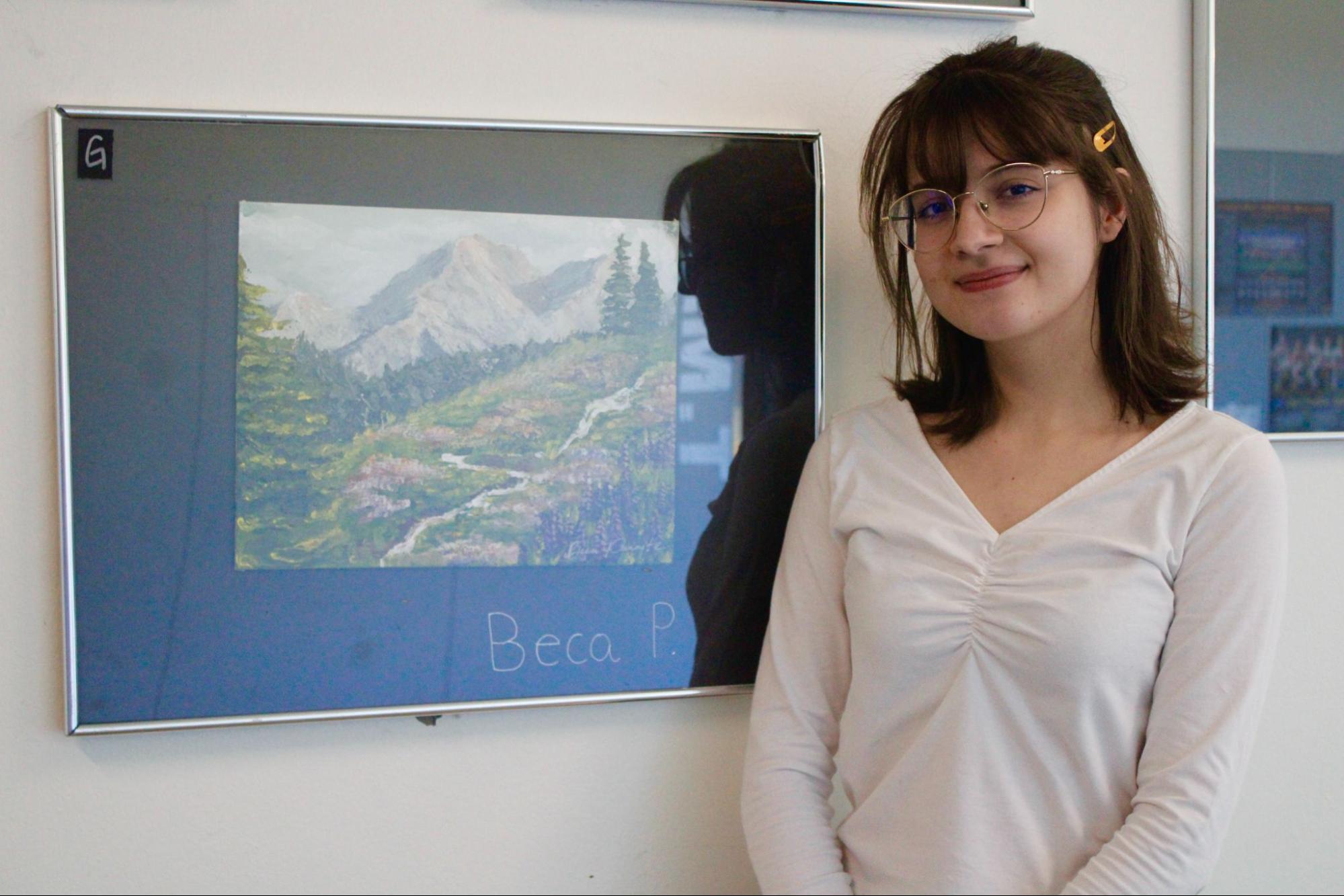 Becca Panaite poses beside her landscape painting, a piece she created during Painting 1.

