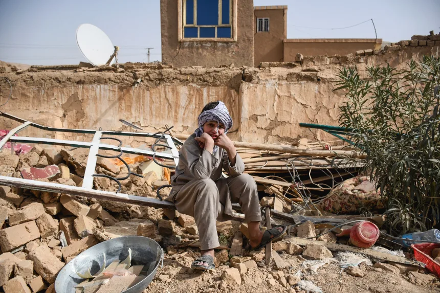 An Afghanistan citizen sitting on the top of the rubble of a collapsed building caused by a 6.3 earthquake on Nov, 3rd.