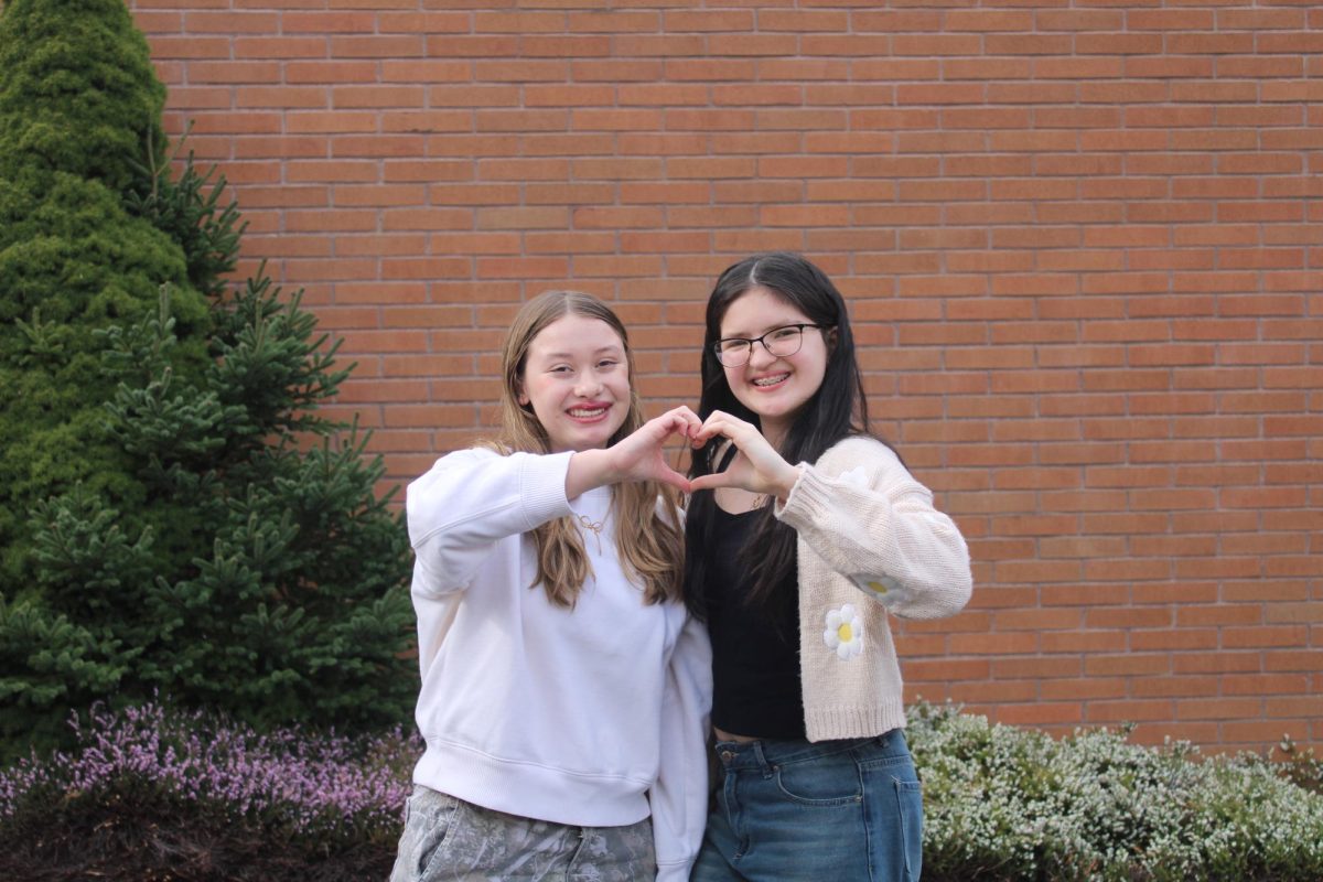 Photo of Brennah Rinard (left) and Jayden Garcia Inciong (right) making a hand heart.