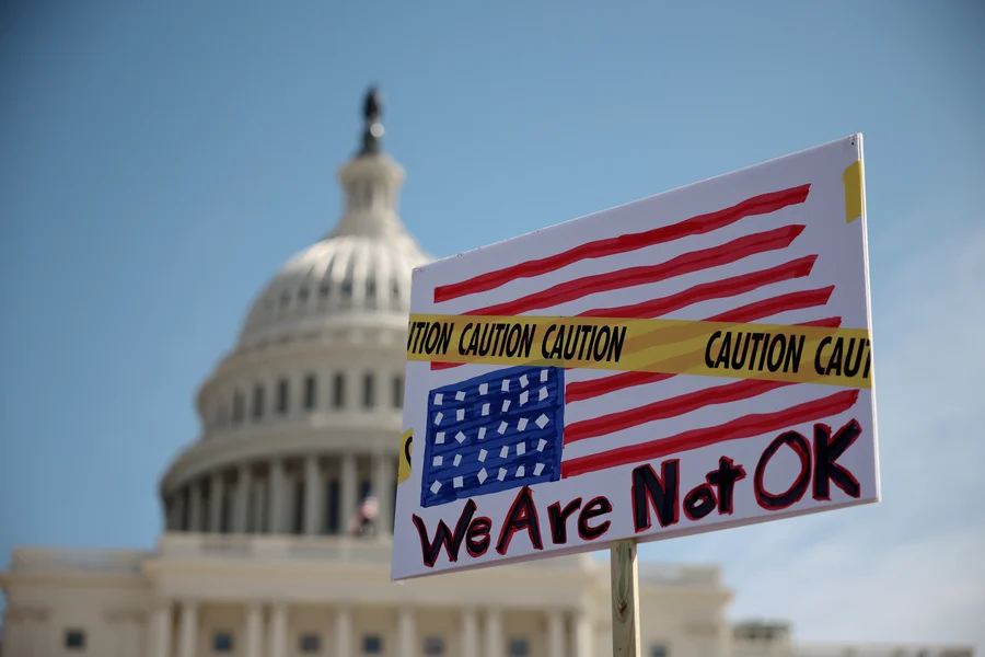 A participant holds a "We are not ok" sign during the "Shut Down the Coup" protest on the West Lawn of the U.S. Capitol on March 10, 2025 in Washington, DC.


