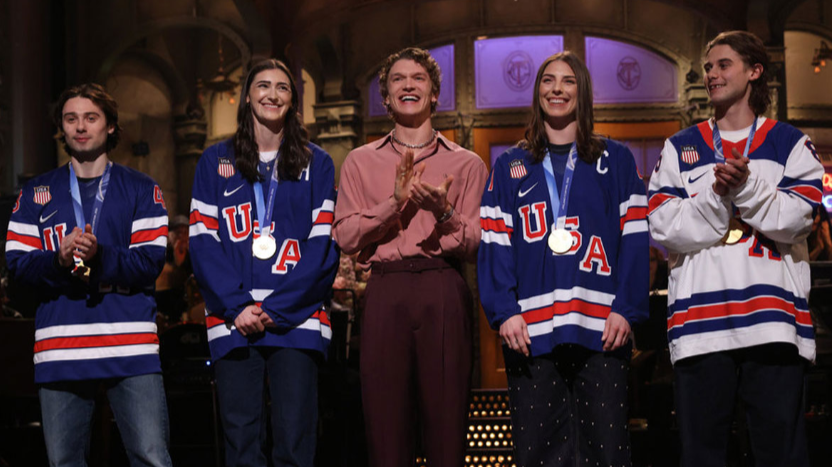 Megan Keller, Hillary Knight, Connor Storrie, Quinn Hughes, and Jack Hughes on the SNL stage for Storrie’s opening monologue.