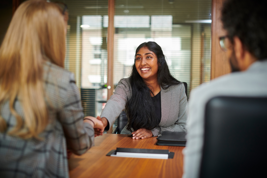 A candidate and hiring manager shaking hands after an interview.